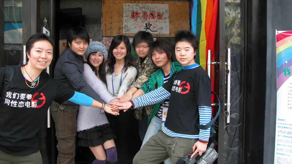 group of young chinese poeple. Two wearing t-shirts stating "We Want to Watch Queer Film". photo. 