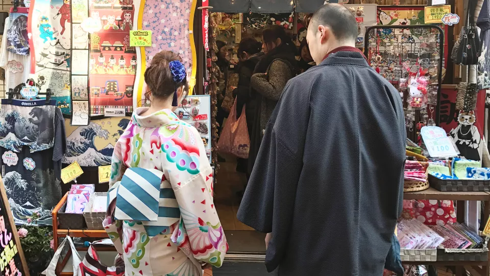 japanese couple in traditional clothes looking at souvenirs