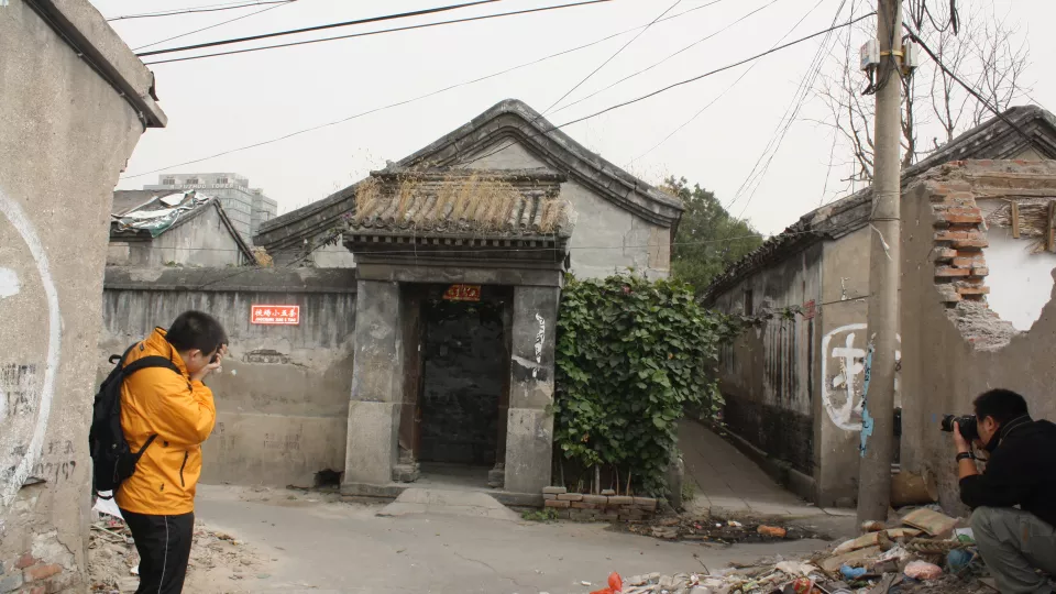 two men taking photos of old building in China