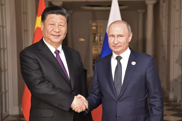 Xi Jinping and Putin shaking hands. Photo