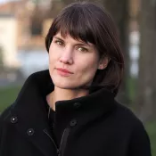 colour photo headshot of woman with dark hair outside in winter sun